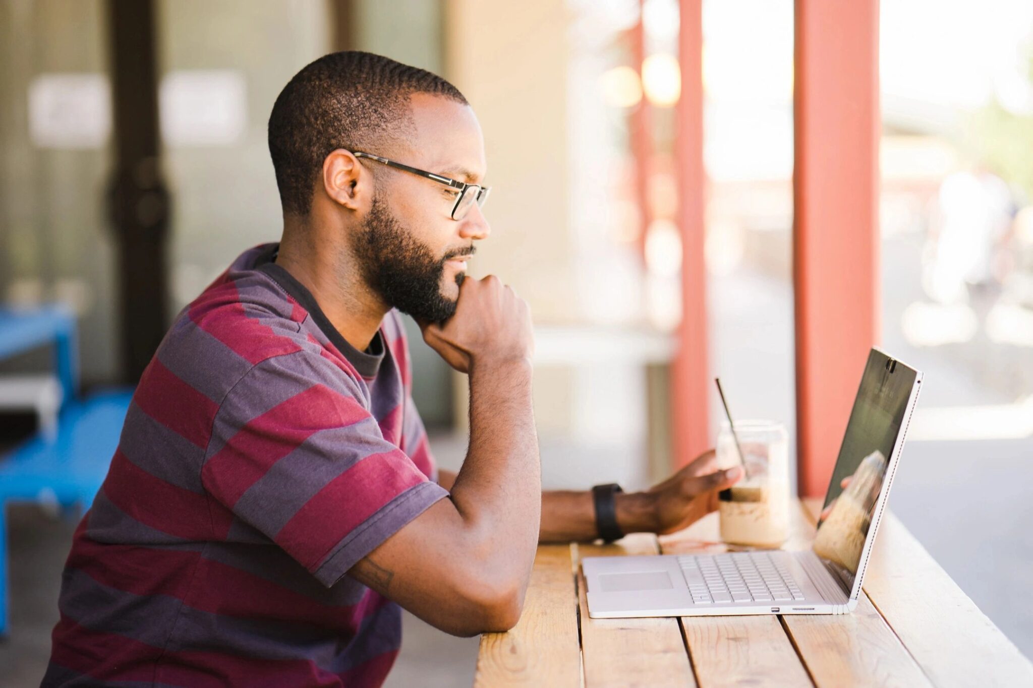 A man sitting at a table with his laptop.