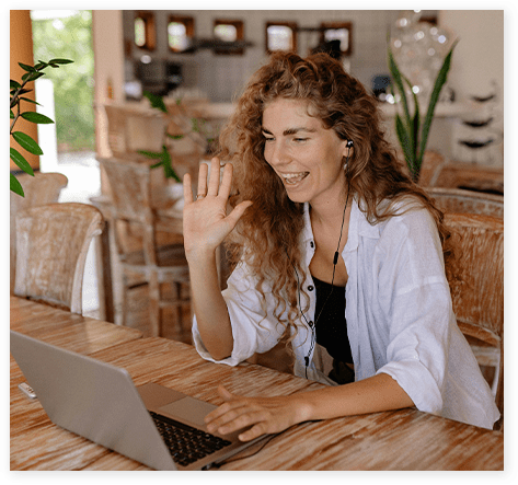 A woman sitting at a table with her laptop.