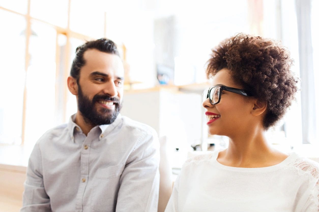 A man and woman smiling at each other.