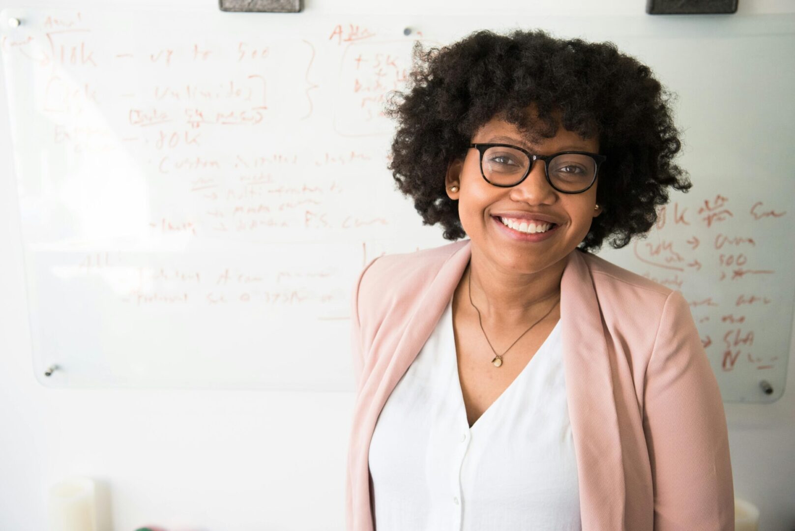 A woman with glasses smiling for the camera.