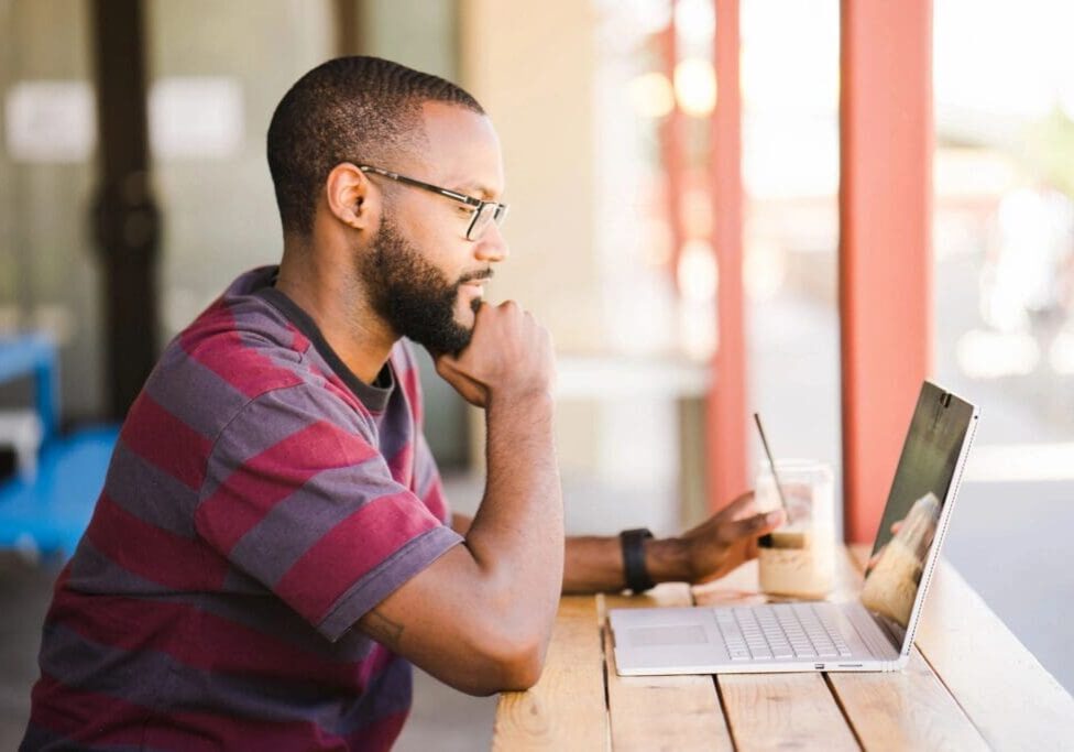 A man sitting at a table with his laptop.