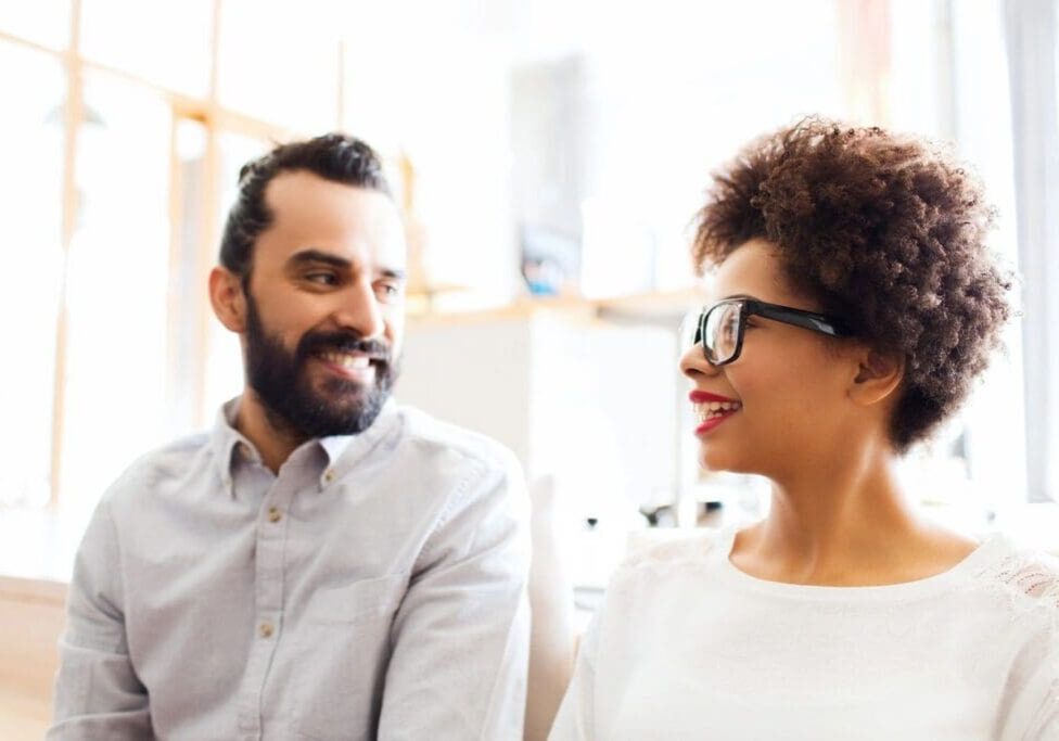 A man and woman smiling at each other.