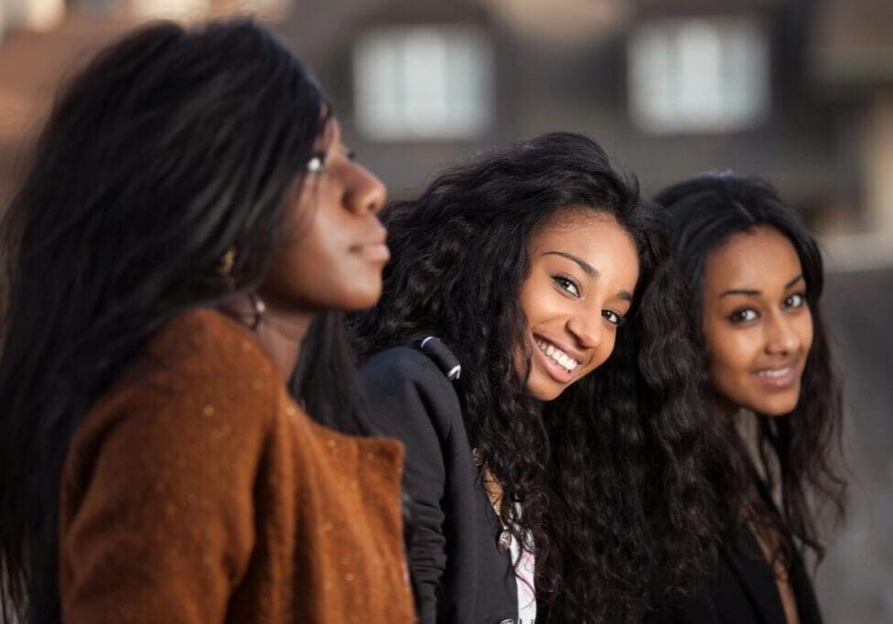 Three women are smiling and posing for a picture.