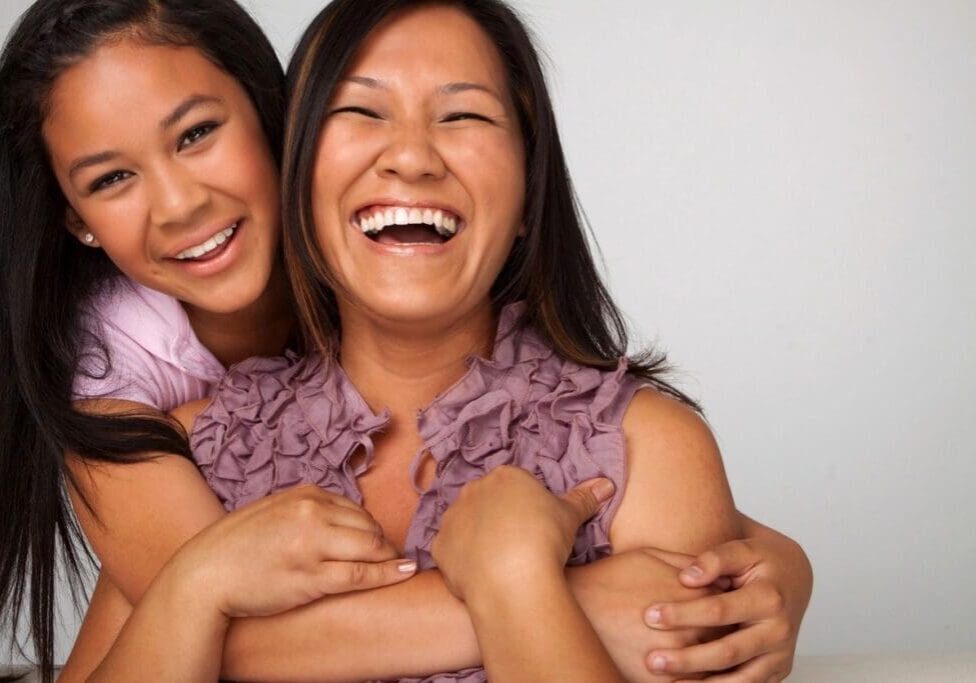 Two women smiling and hugging each other.